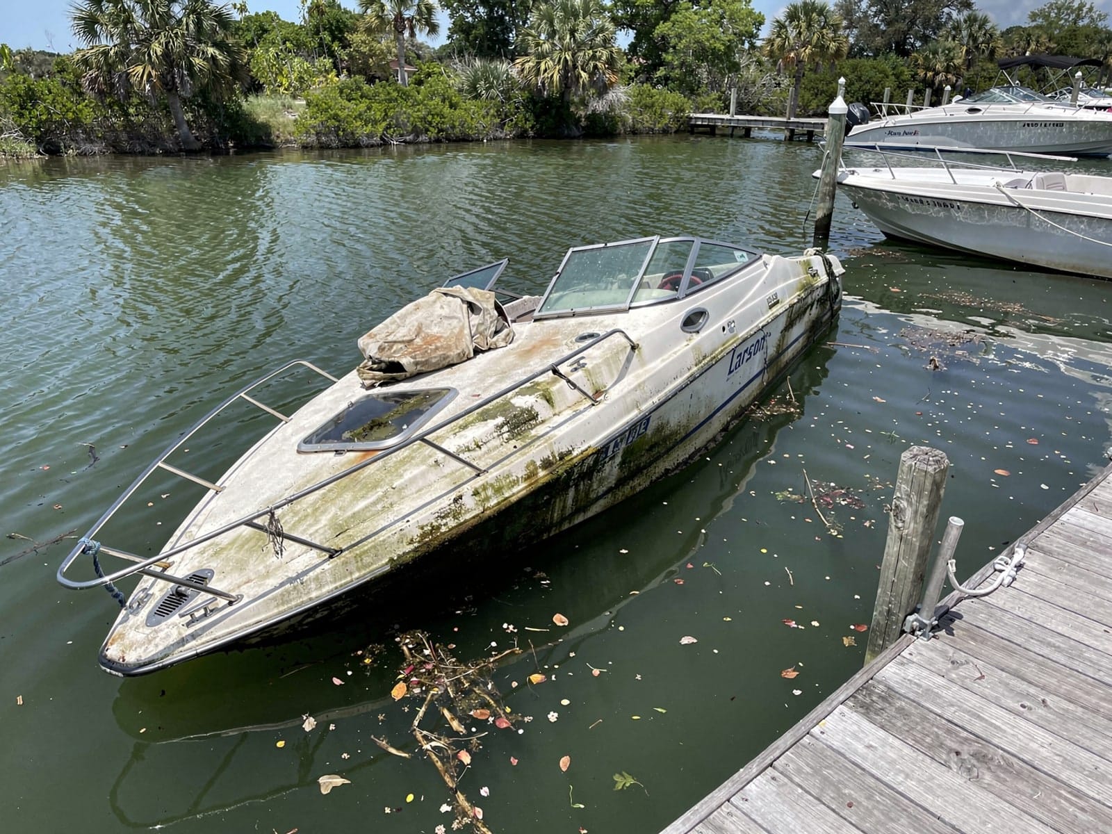 Sunken 22 ft Larson 220 at a lake dock in West Melbourne, FL