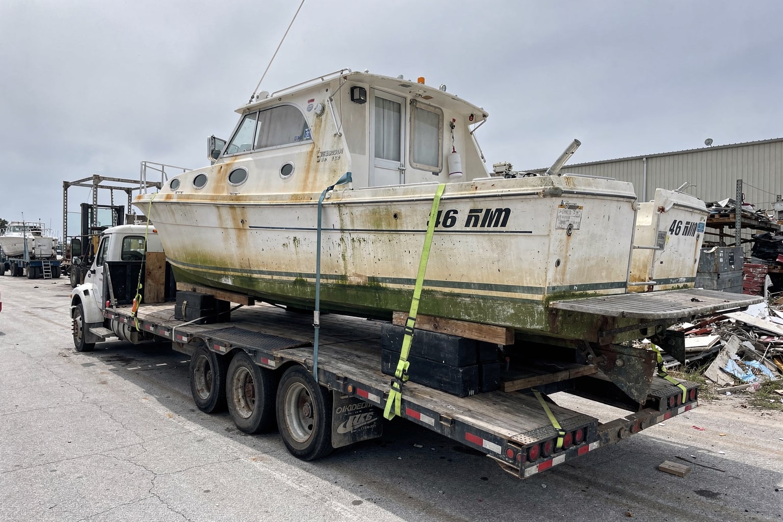 Boat removal team inspecting a boat on a truck