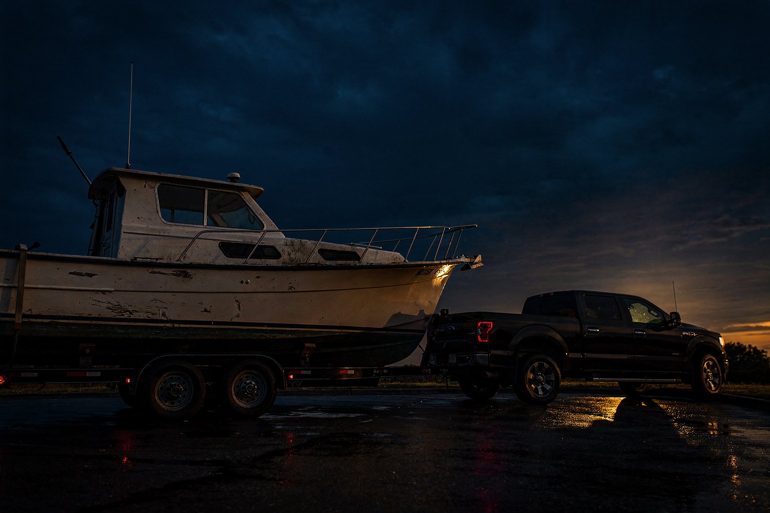 Boat removal and disposal, done right the first time — flatbed truck hauling a junk boat away